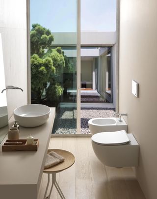 light coloured bathroom with large windows and neutral scheme