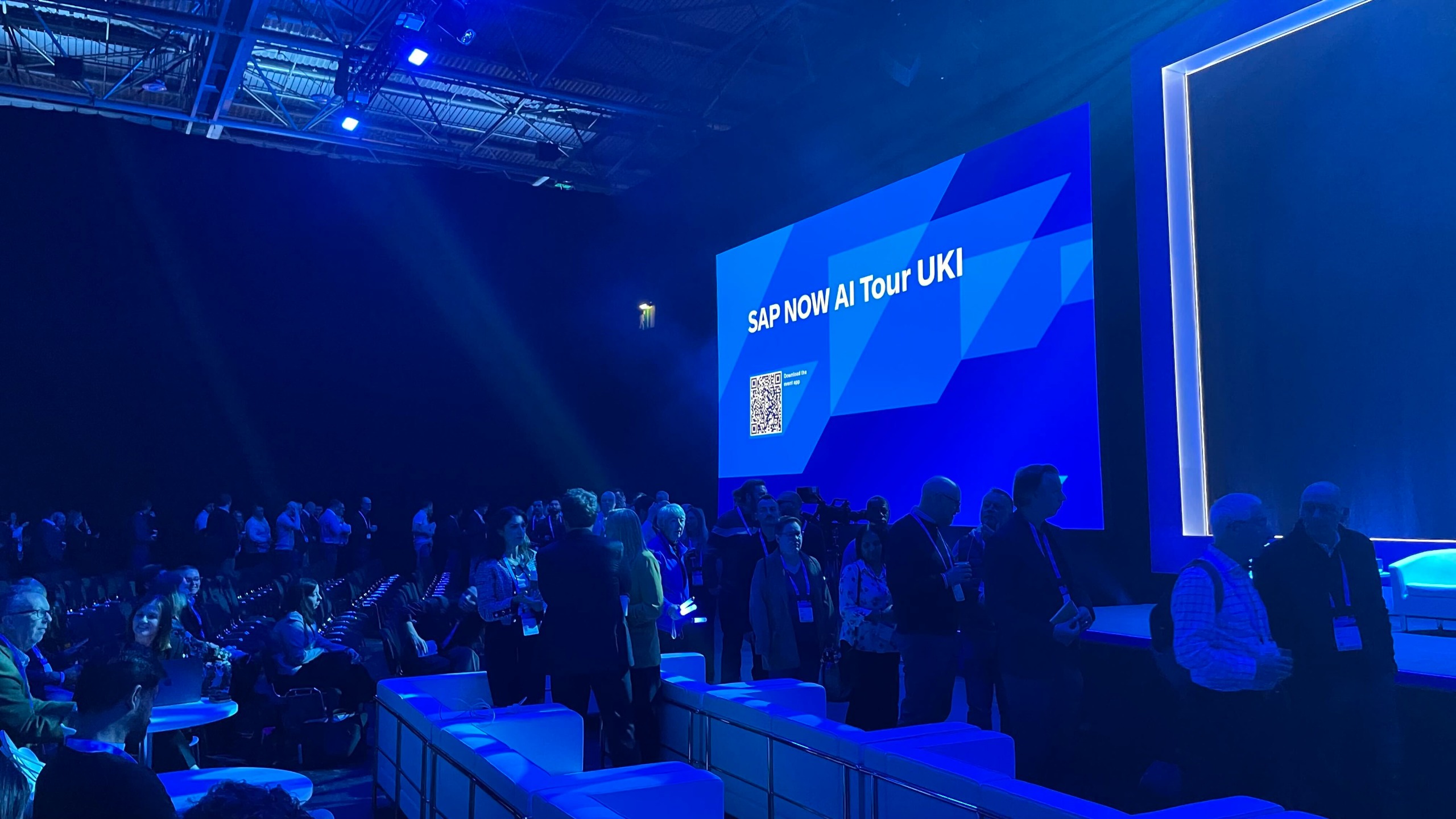 Crowds entering the main auditorium for the SAP NOW AI Tour 2026 keynote at the NEC Birmingham, lit in blue. There's a screen saying SAP NOW AI Tour UKI behind them
