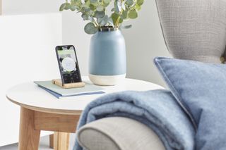 phone with smart heating app in a living room