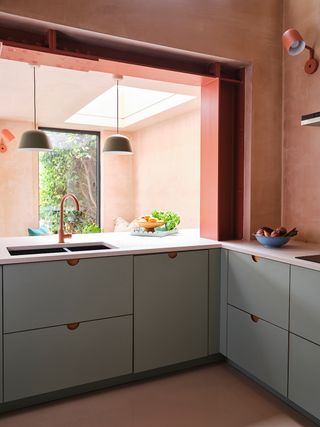 blue kitchen cabinets with white countertop and plaster pink walls
