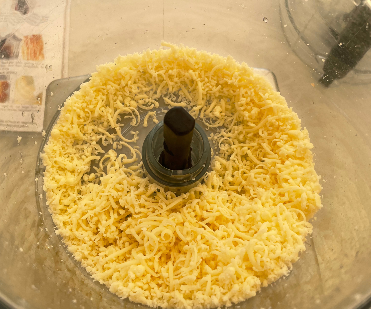 Finely grated cheese in the base of a food processor unit.