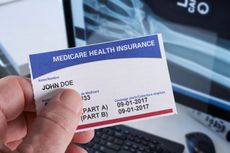 A hand holds a Medicare health insurance card