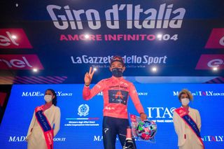 Oveall leader Team Ineos rider Colombias Egan Bernal celebrates on the podium after winning the 16th stage of the Giro dItalia 2021 cycling race 153km between Sacile and Cortina dAmpezzo on May 24 2021 Photo by Luca Bettini AFP Photo by LUCA BETTINIAFP via Getty Images