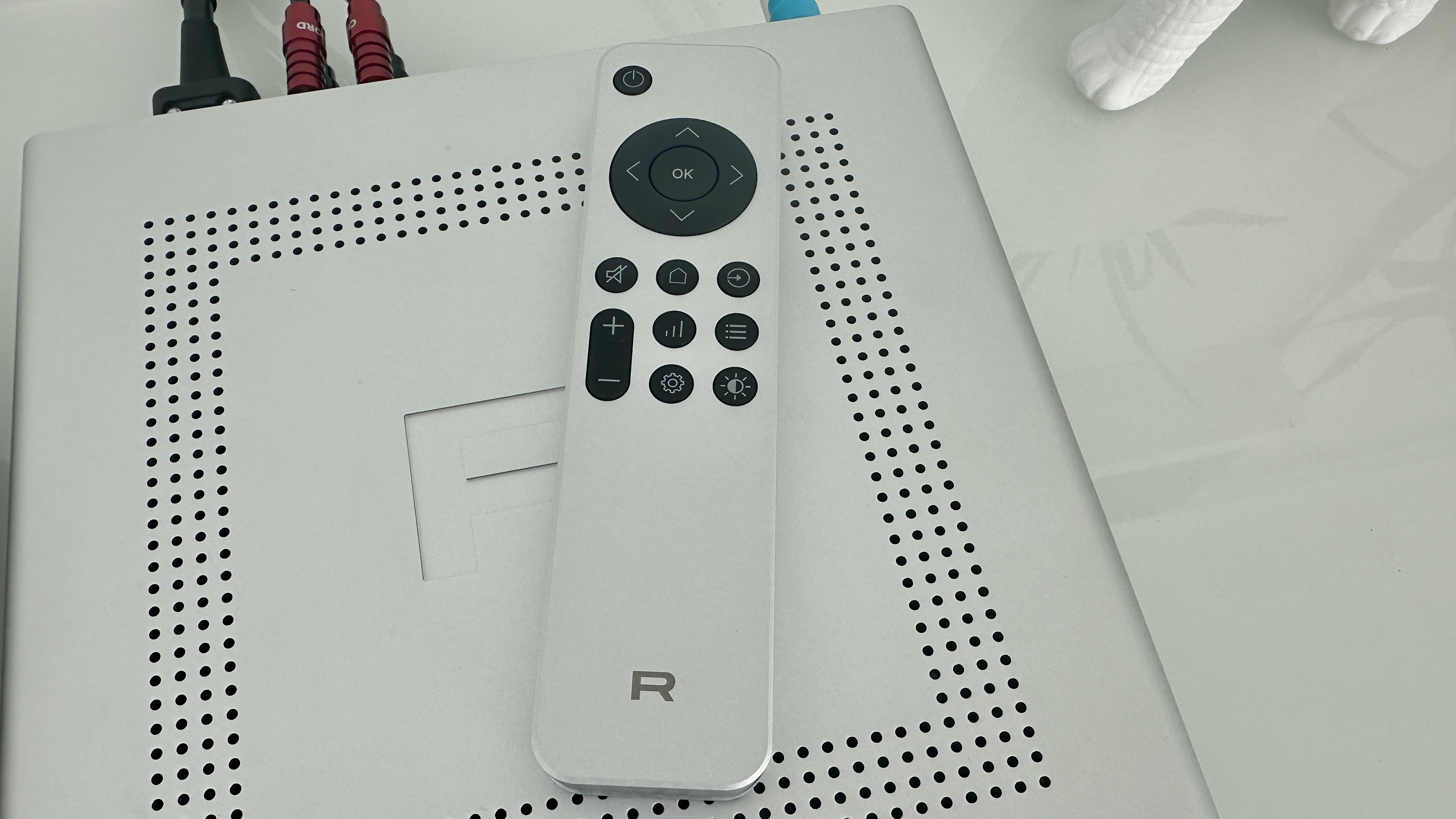 Rotel's DX-5 integrated amp in silver on a light gray table, with the amp's remote visible