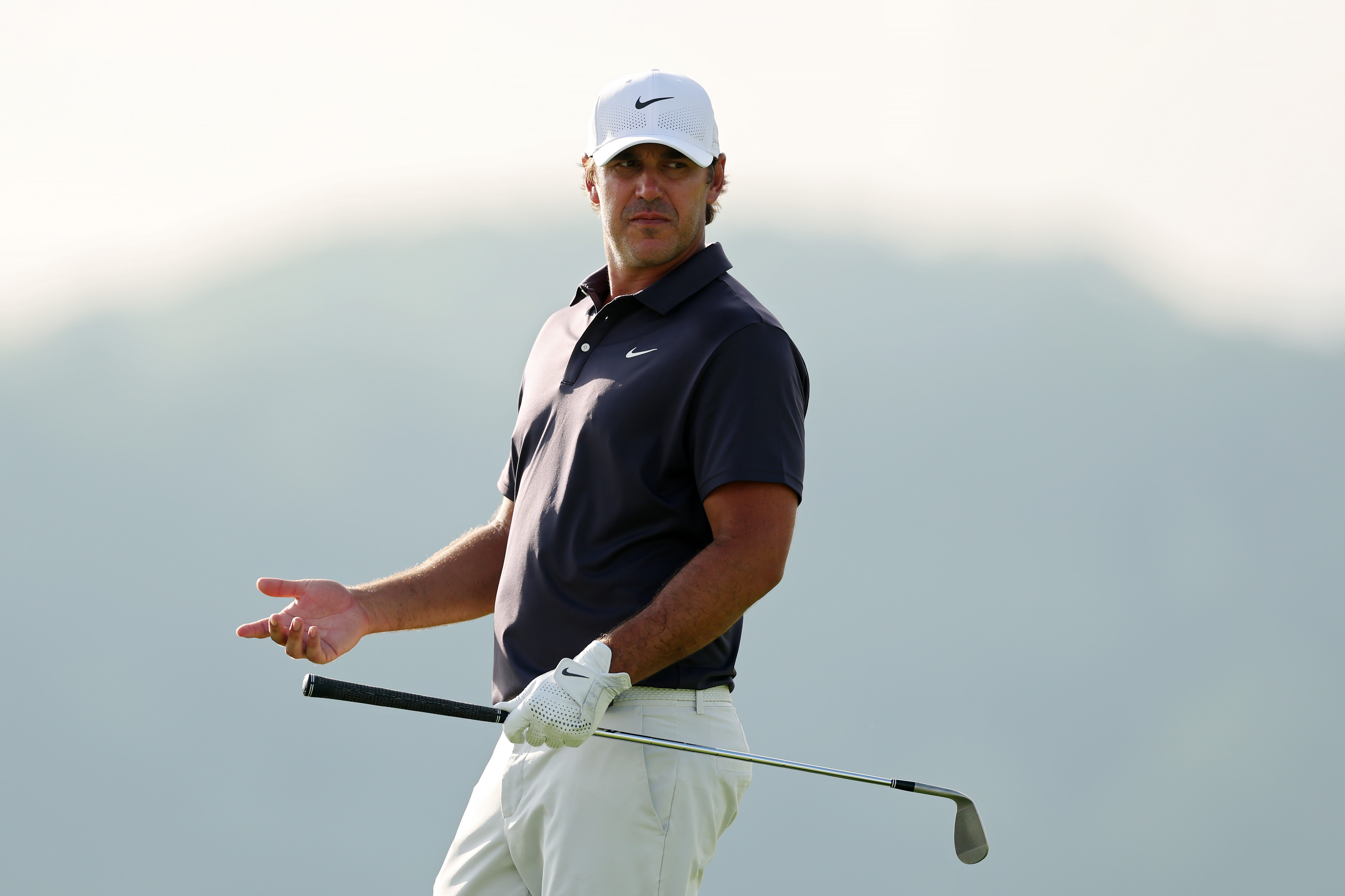 Brooks Koepka raises his hand in the air