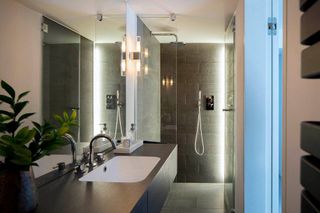 a dark grey ensuite bathroom with an LED lighting strip