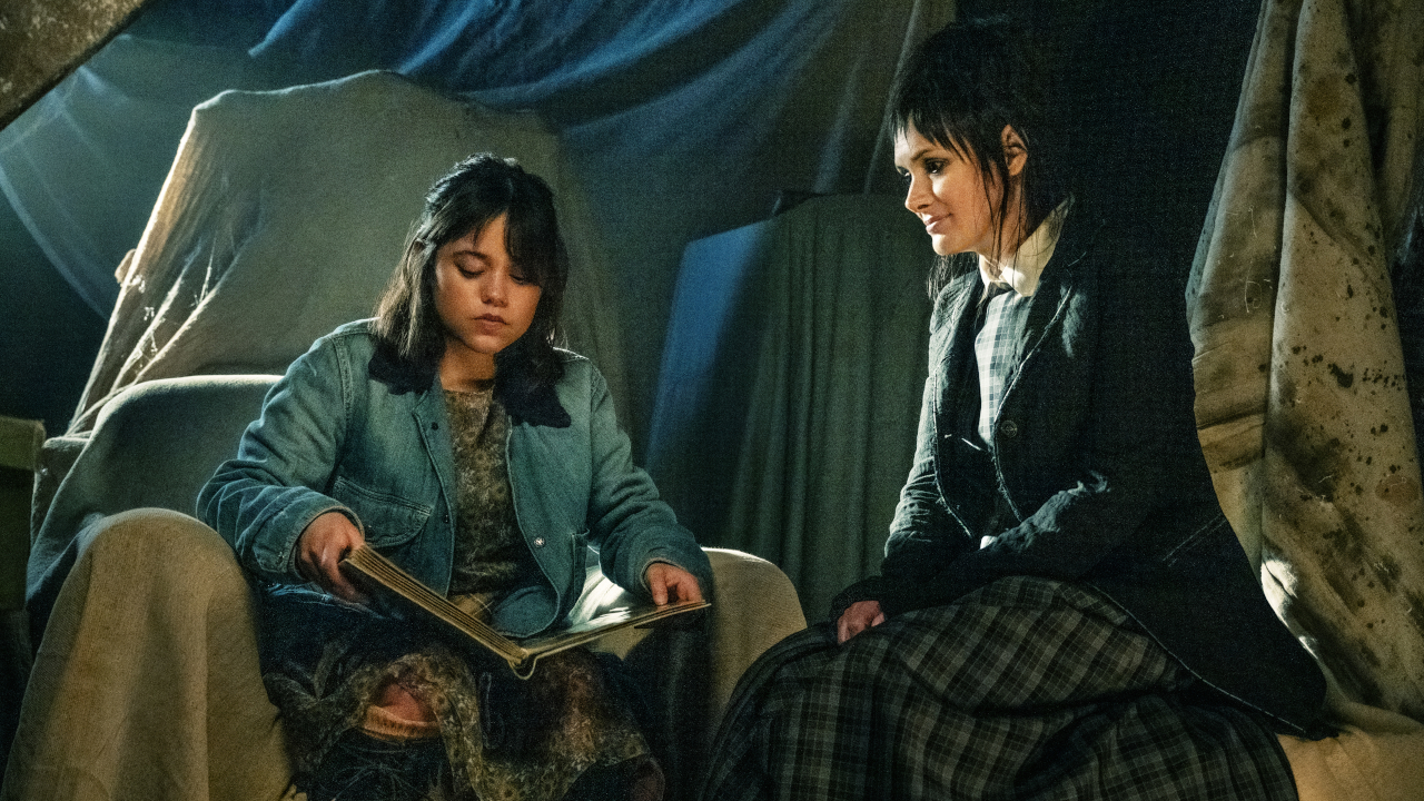 Jenna Ortega studies a photo album while Winona Ryder watches on smiling in Beetlejuice Beetlejuice.