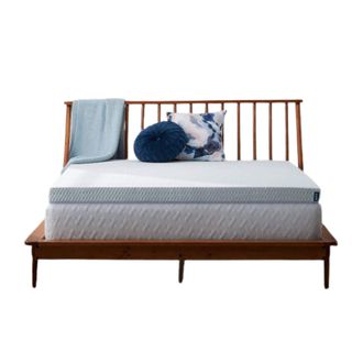 A blue mattress topper on a wooden bed frame