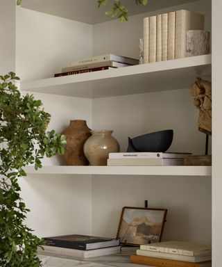 A bookshelf lined with books and decorative items designed by Studio McGee