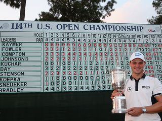 Martin Kaymer with the 2014 US Open trophy in front of the leaderboard at Pinehurst No.2