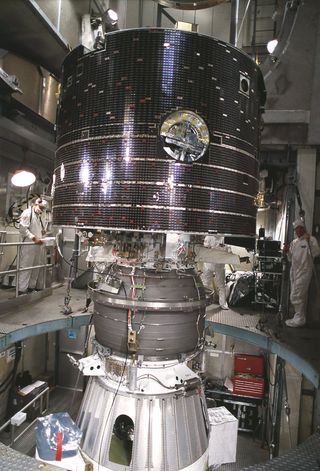 Workers at Launch Complex 17 Pad A, Kennedy Space Center (KSC) encapsulate the Geomagnetic Tail (GEOTAIL) spacecraft (upper) and attached payload Assist Module-D upper stage (lower) in the protective payload fairing.