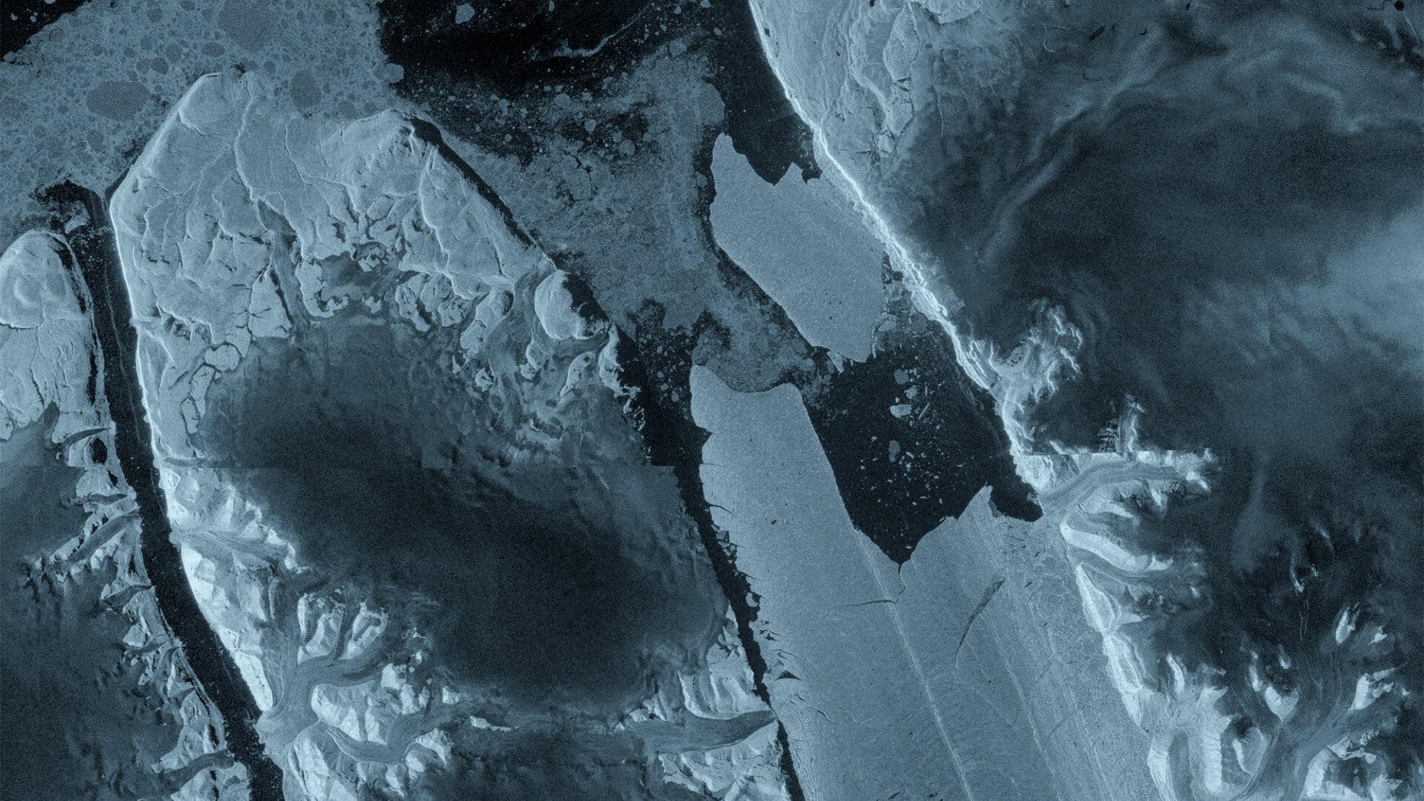A variety of shades of dark blue, gray and white in large panels of ice and water. 
