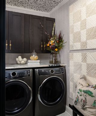 A washer and dryer in a laundry room with white textured artwork on the walls
