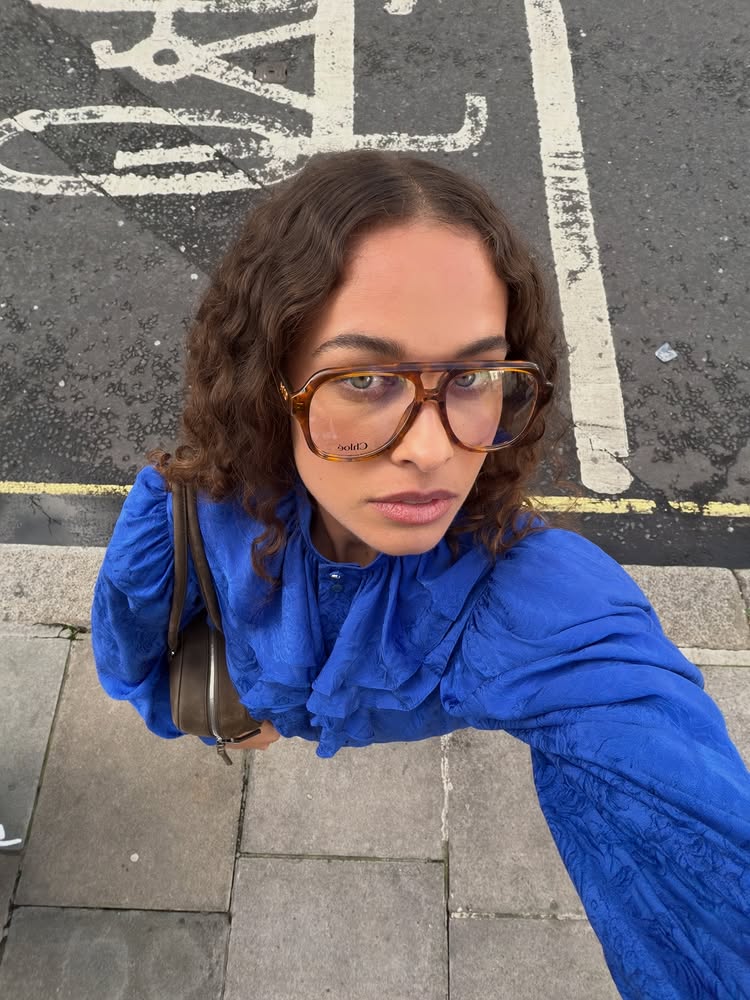 An image of @sarahlysander wearing a cobalt blue frilled top with tortoiseshell Chlo&amp;eacute; glasses.