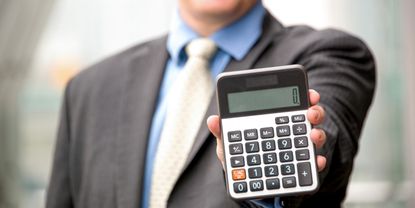 A man holds up a calculator.