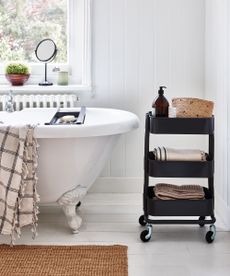 Black trolley used as storage in bathroom