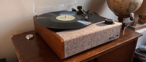 The Victrola Eastwood II turntable on a wooden surface next to a globe.