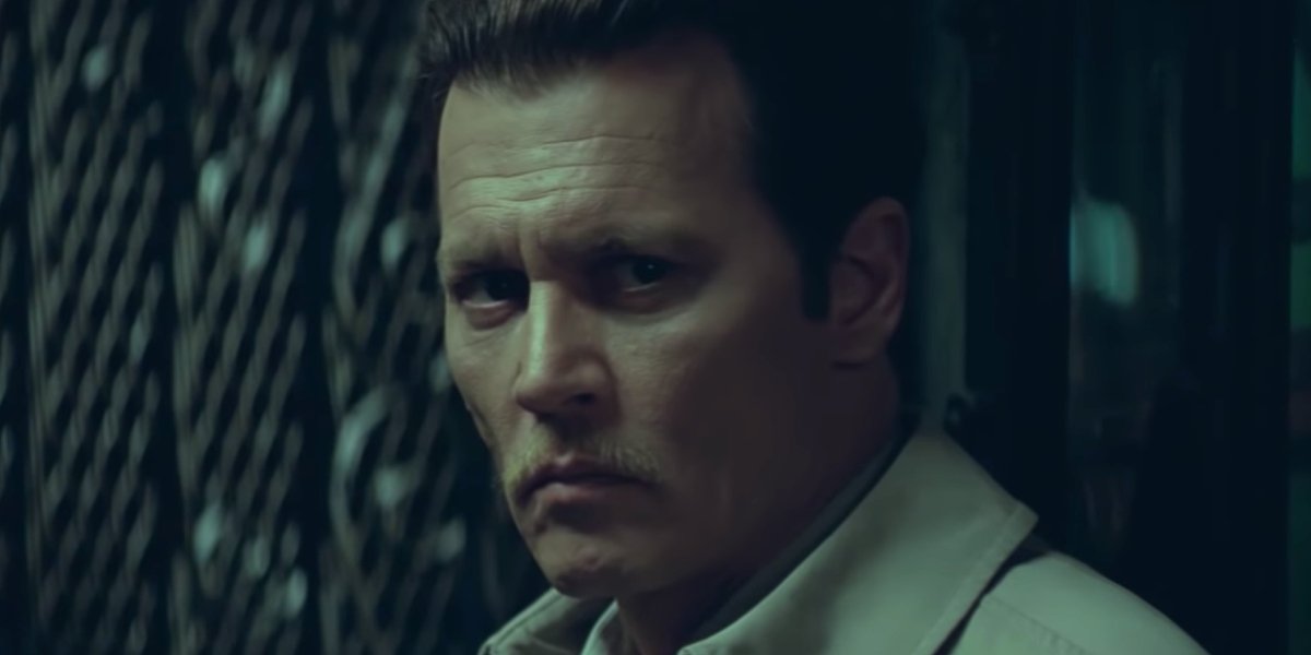 Johnny Depp stands in front of a gate, looking worried in City of Lies