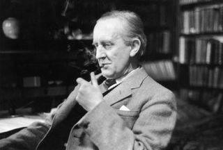 British writer J R R Tolkien (1892 - 1973), enjoying a pipe in his study at Merton College, Oxford,