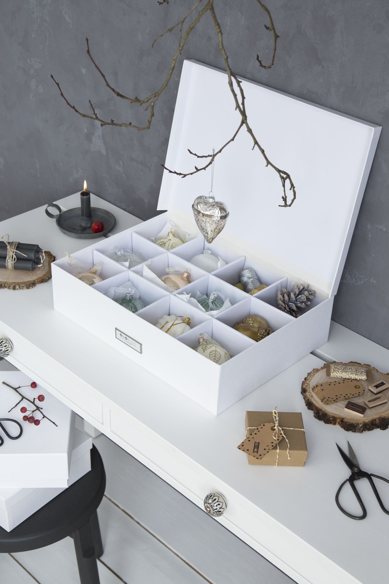 White Christmas decoration box on a desk with gray walls