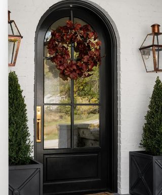 Black front door with fall wreath