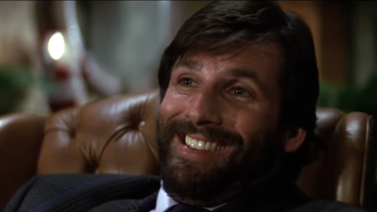 Hart Bochner as Ellis smiling smugly in Die Hard