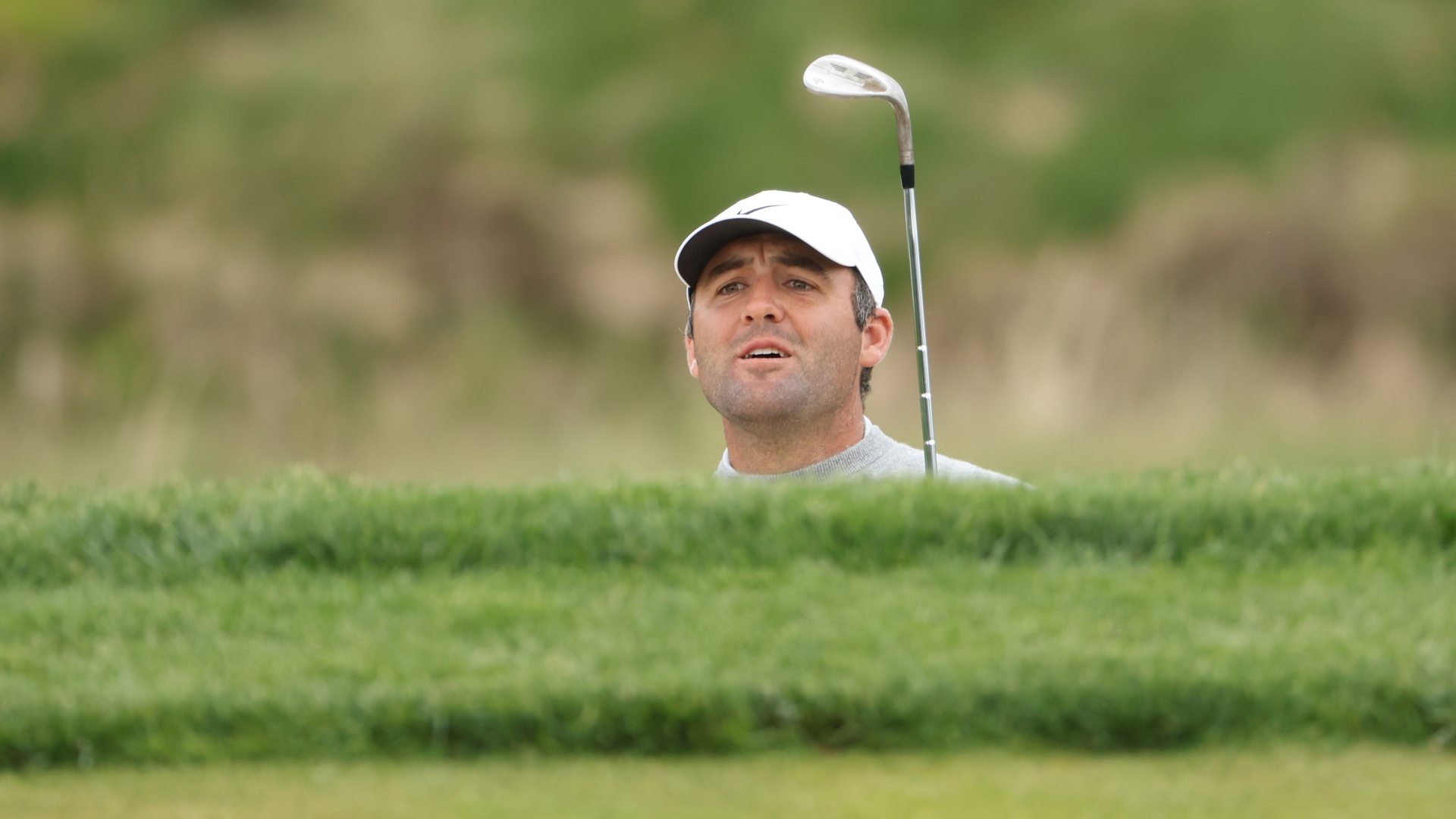 Scottie Scheffler watches his shot from a bunker on the eighth hole during the first round of the 2026 PGA Championship at Aronimink Golf Club