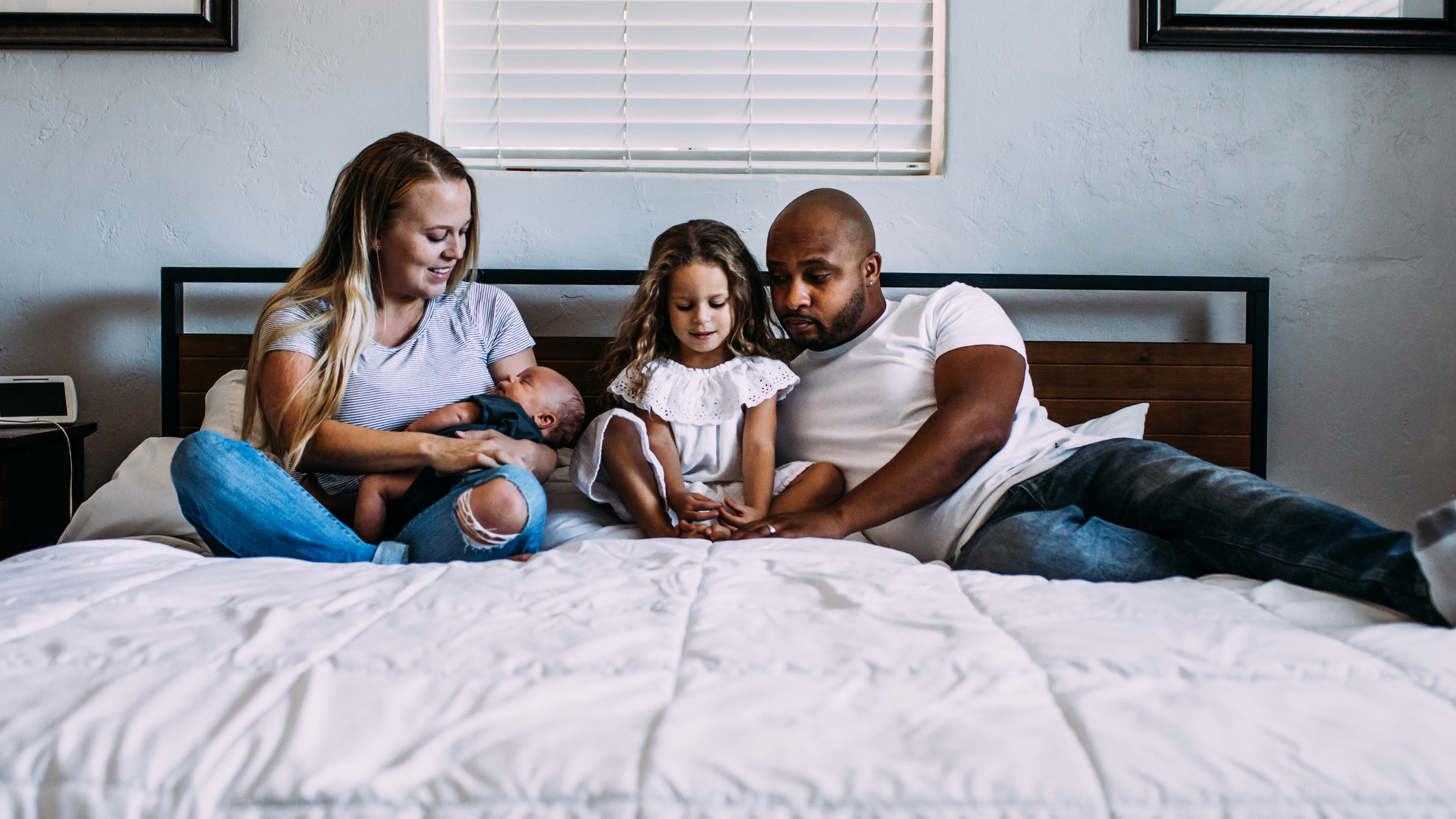 A young family of four lie on a king size mattress together