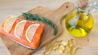 A selection of sources of omega-3 including a salmon fillet, olive oil and omega-3 in the form of supplements