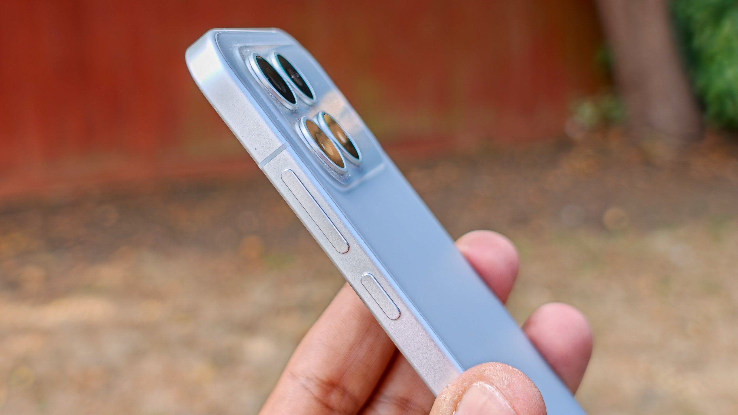 The Poco F8 Pro in Silver in the hand against a garden backdrop
