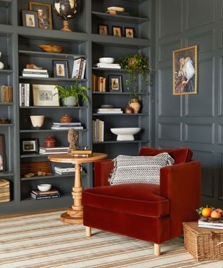 Living room with blue painted walls, rich red lounge chair with wooden side table