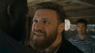 Conor McGregor smiling and getting up in a guy's face in Road House.