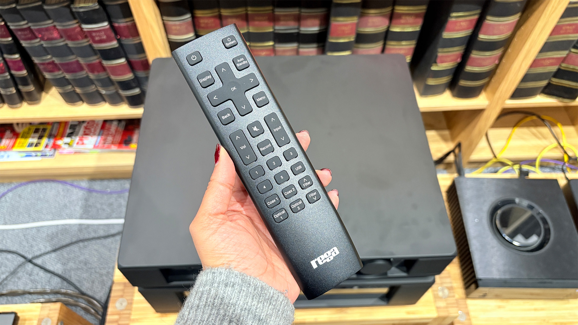 Rega Mercury/Solis pre/power amplifier with remote control held in hand above it