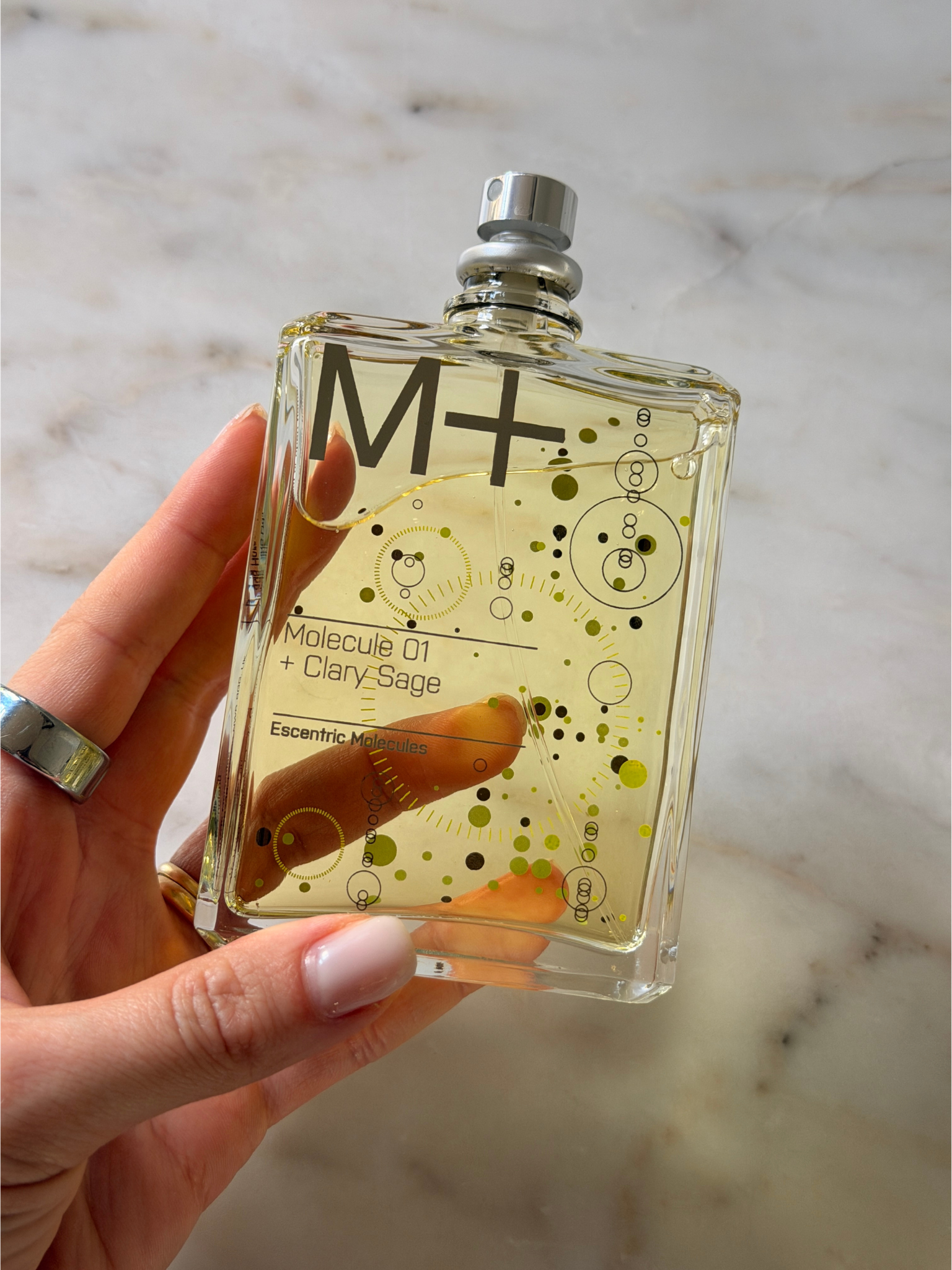 Grace holding a bottle of Escentric Molecules perfume
