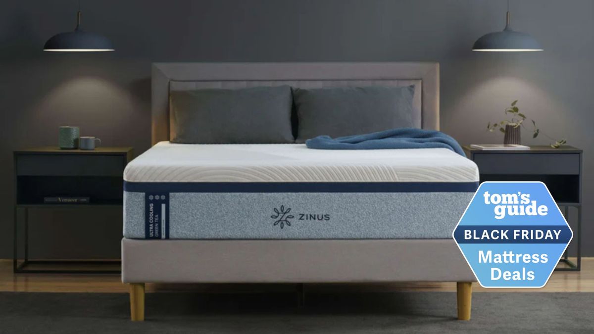 The Zinus Ultra Cooling Green Tea Memory Foam Mattress in grey bedroom with two lights coming down from ceiling and two bedside tables either side of bed.