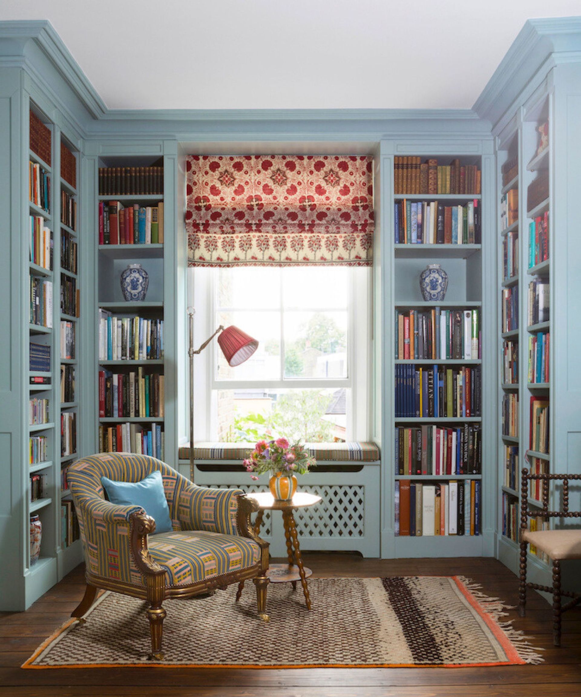 Library nook with blue fitted joinery and a patterned fabric blind. Interior by Kate Guinness, photograph James McDonald