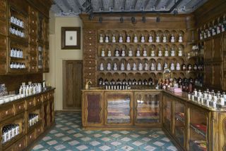 An old-style perfumery shop features tiled floors and wooden cabinets filled with precious blends.