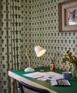 Eclectic home office with matching green patterned wallpaper and curtains