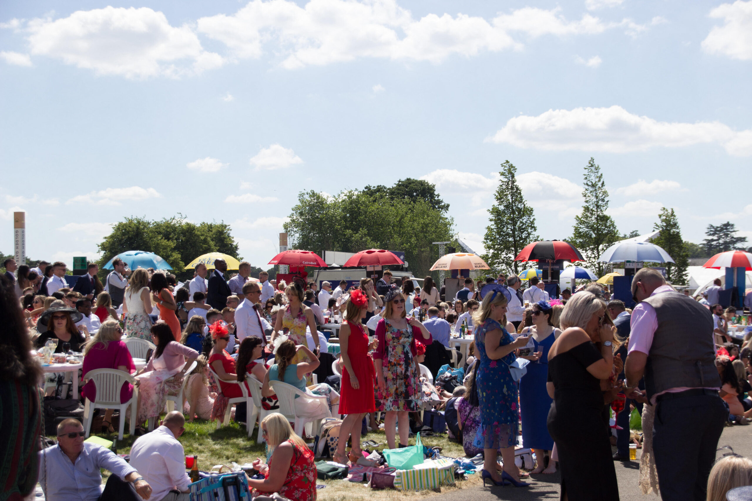 Crowds standing watching the races at Royal Ascot in the Windsor Enclosure where there is no dress code