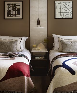 neutral twin bedroom with monochrome artwork and colorful fringed bed throws