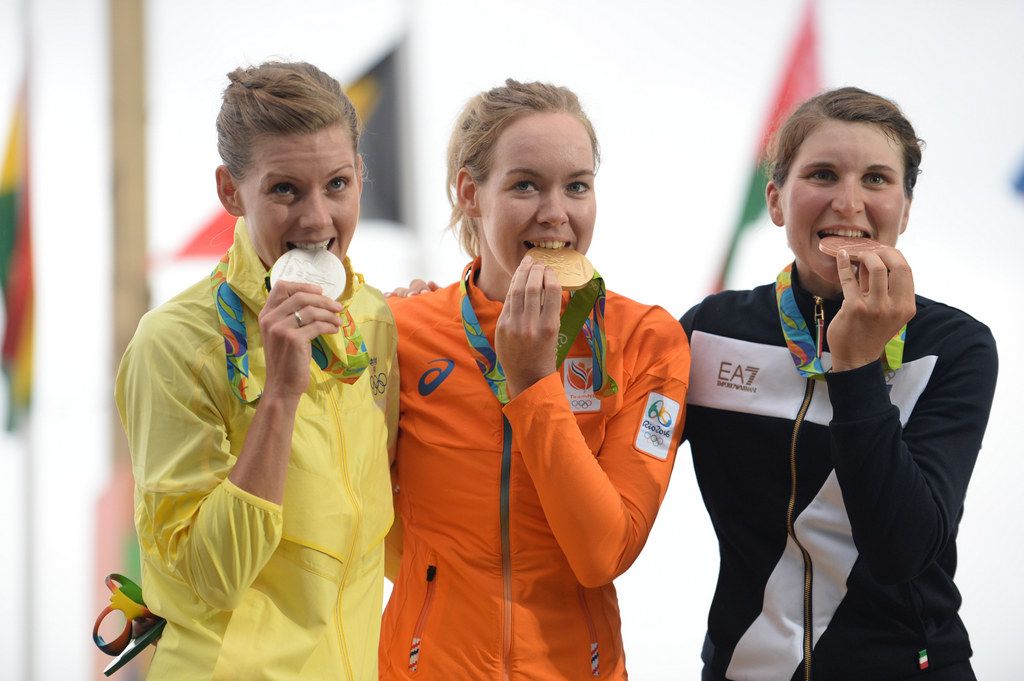 The podium riders take a bite of their medals