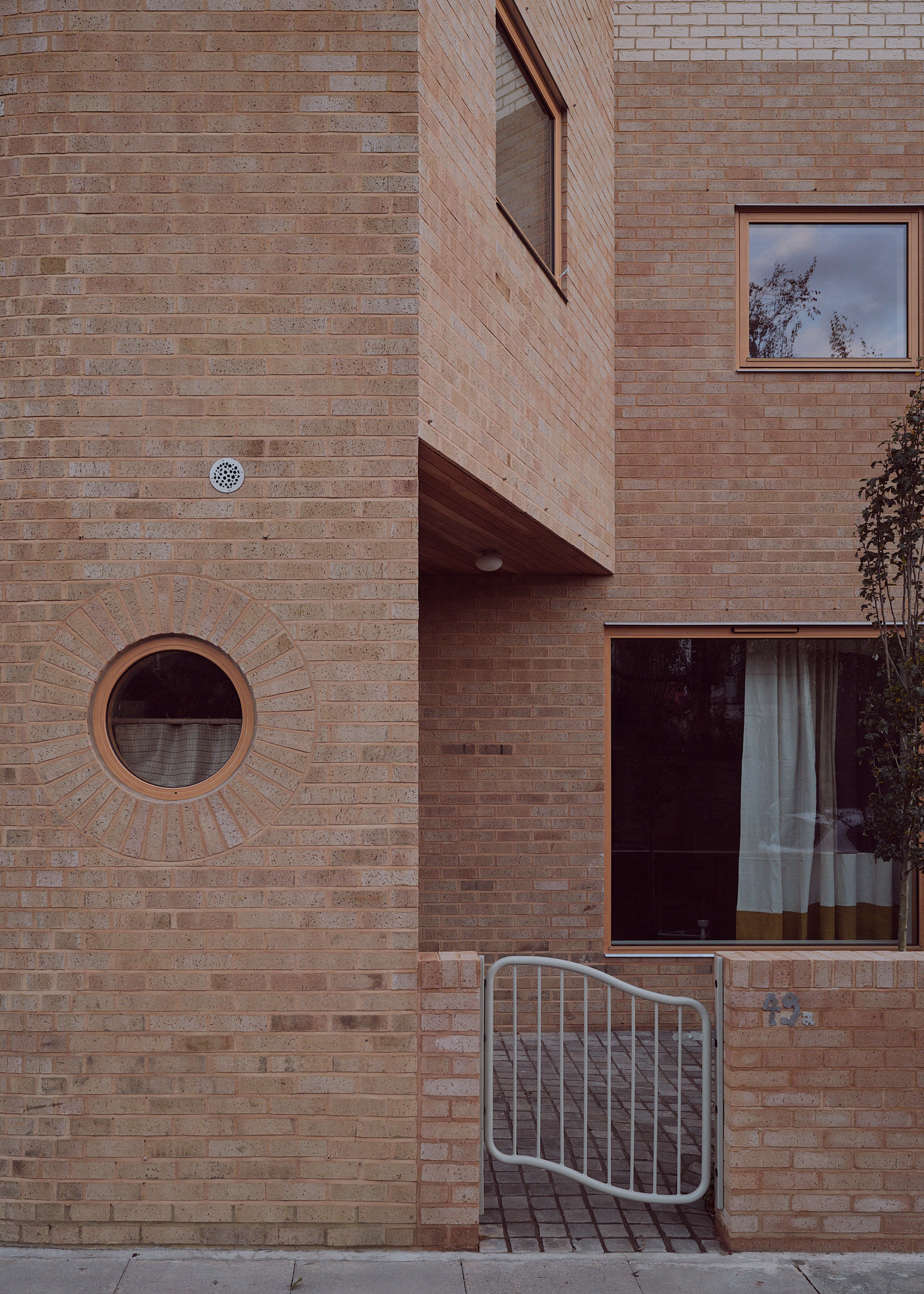entrance to a home with a curved metal gate and brick exterior