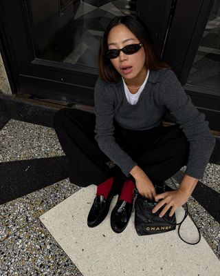 @aimeesong wearing jeans, jumper, red socks and loafers