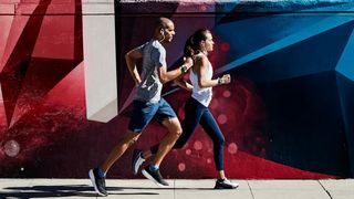 Man and woman running wearing Garmin Forerunner 245 watches