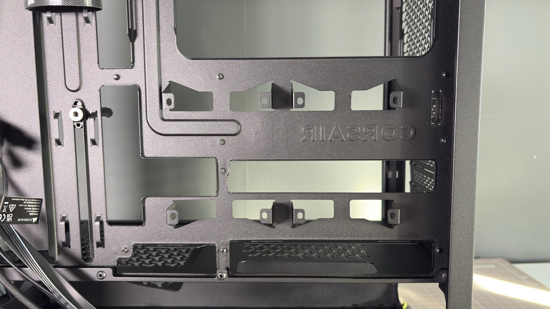 A Corsair PC case, the 3200D, on a desk with various panels removed and ready for a PC build.