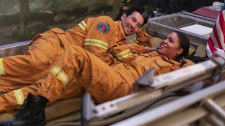 Jay Hayden as Travis Montgomery and Barrett Doss as Vic Hughes lie on a firetruck on Station 19.