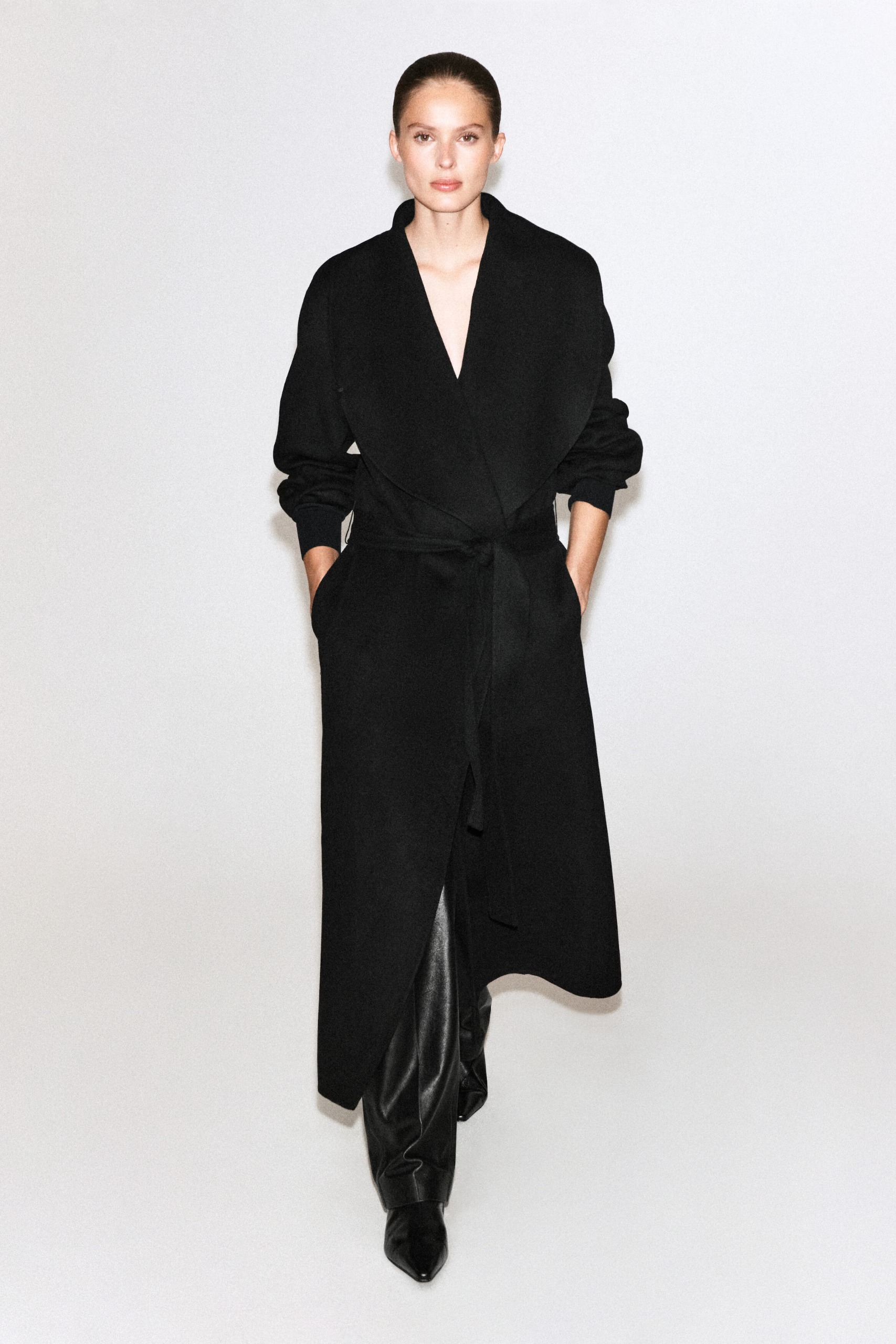 cos model wearing wool black coat