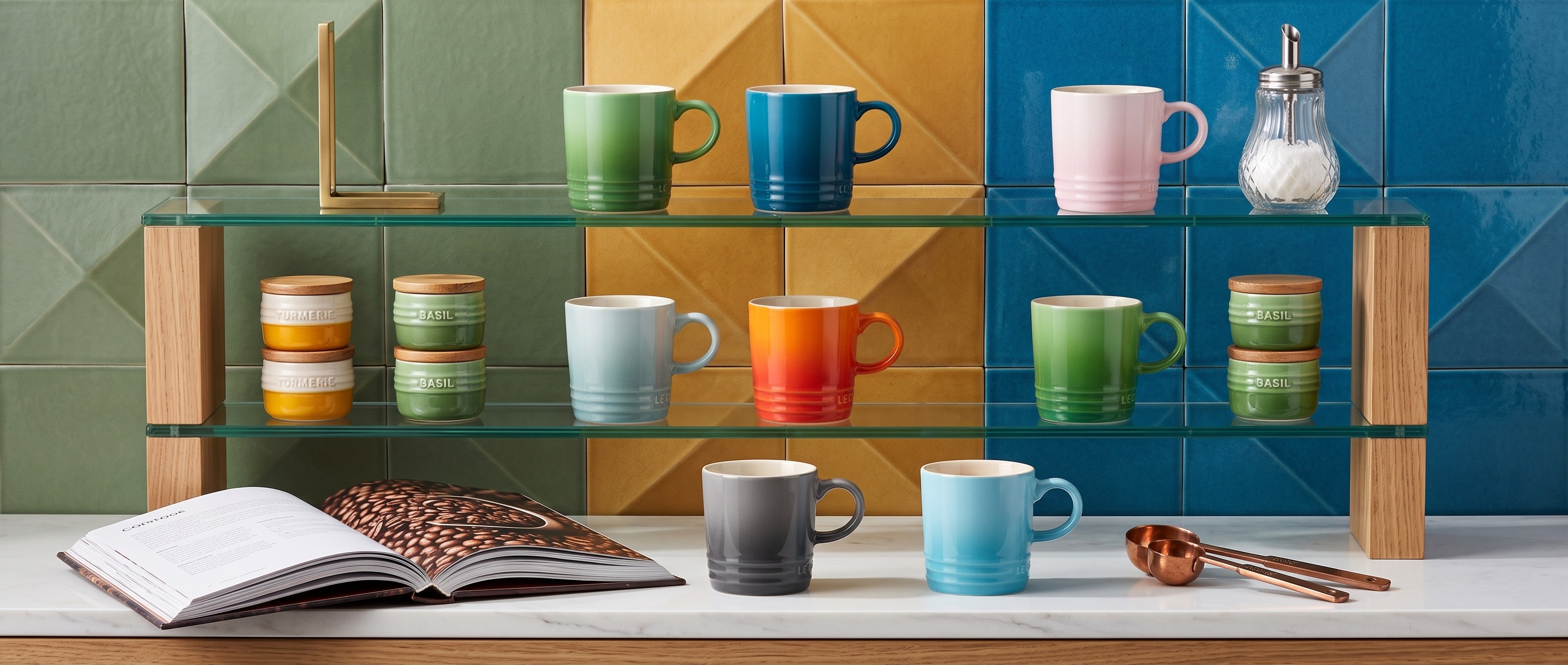 Collection of multicolored Le Creuset mugs on shelves