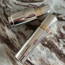 The Lancome Anticipate cream and serum on a marble table