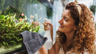 Woman cleaning glass on fish tank